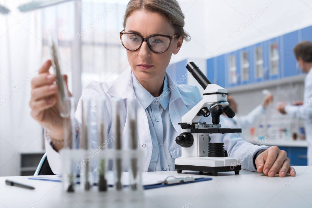 Científica trabajando con un microscopio en un laboratorio